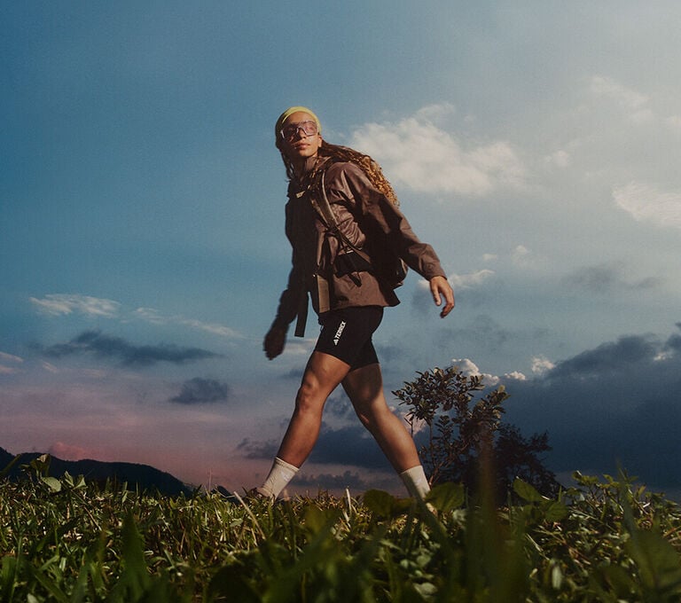 Ragazza che fa trekking in montagna con abbigliamento adidas Terrex
