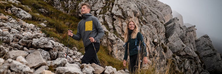 Ragazza e ragazzo che camminano in alta montagna