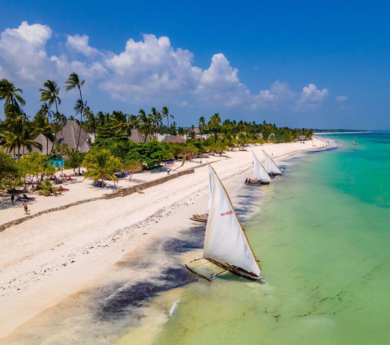 Spiaggia di Zanzibar con barche a vela ormeggiate a riva