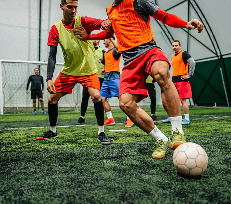 Ragazzi che si scartano su campo indoor da futsal