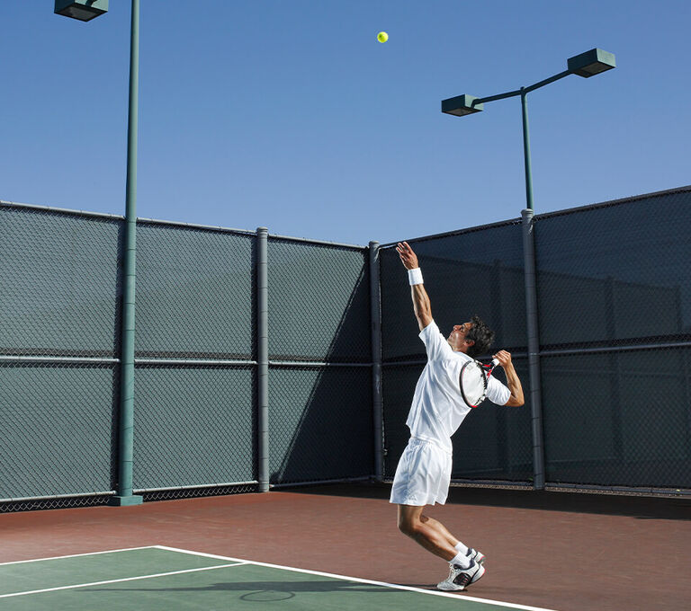 Ragazzo che fa un servizio di tennis in campo