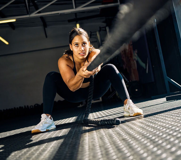 Ragazza che si allena in palestra con tiro della corda