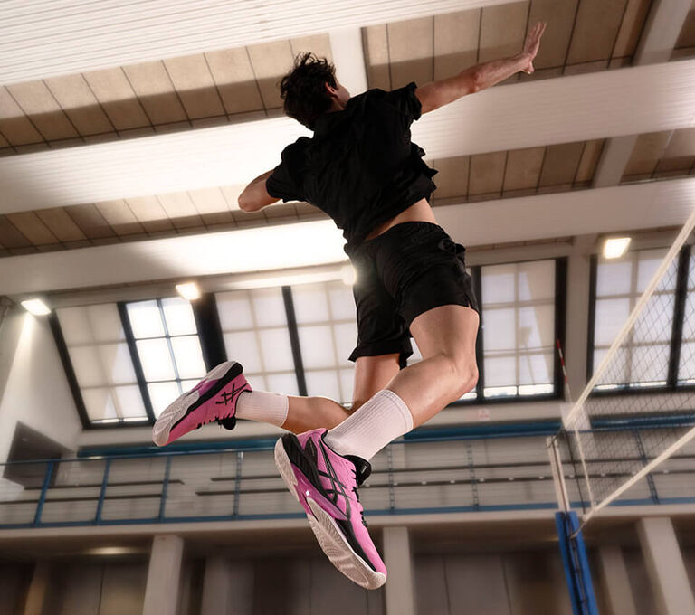 Ragazzo che gioca a volley e salta per fare da muro