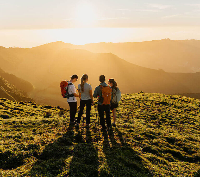 Gruppo di ragazzi che fa trekking al tramonto