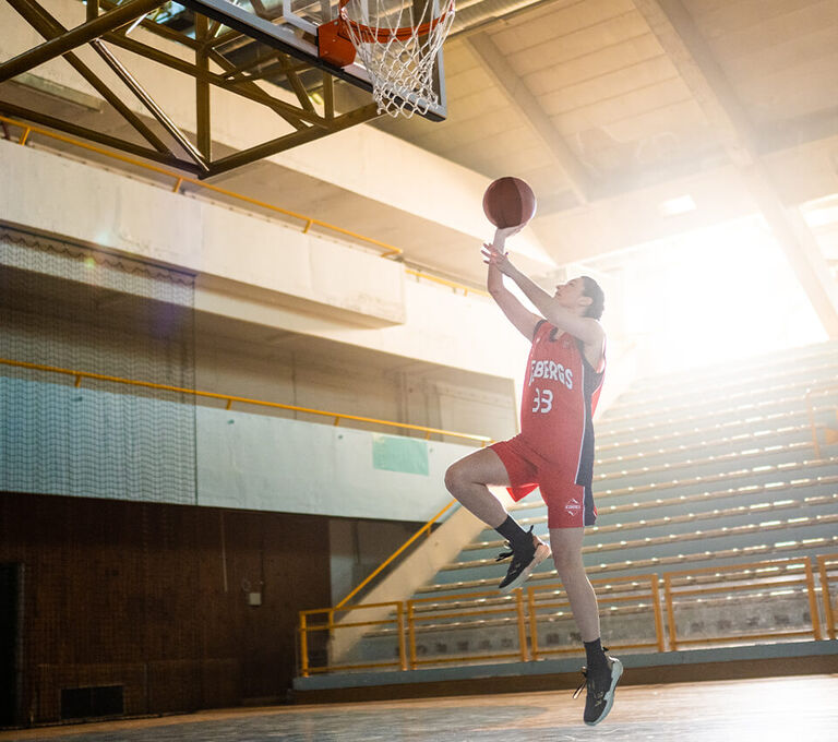 Ragazzo che salta e fa canestro