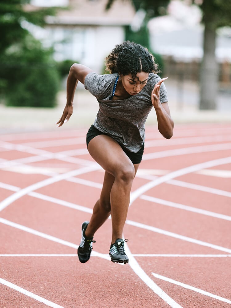 Ragazza che corre su pista di atletica