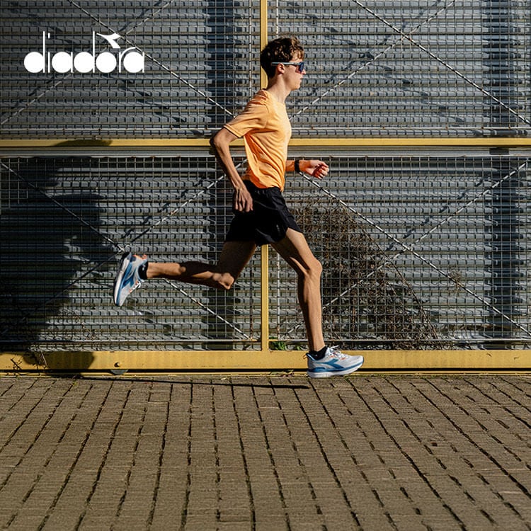 Ragazzo che corre con scarpe da running Diadora Distance