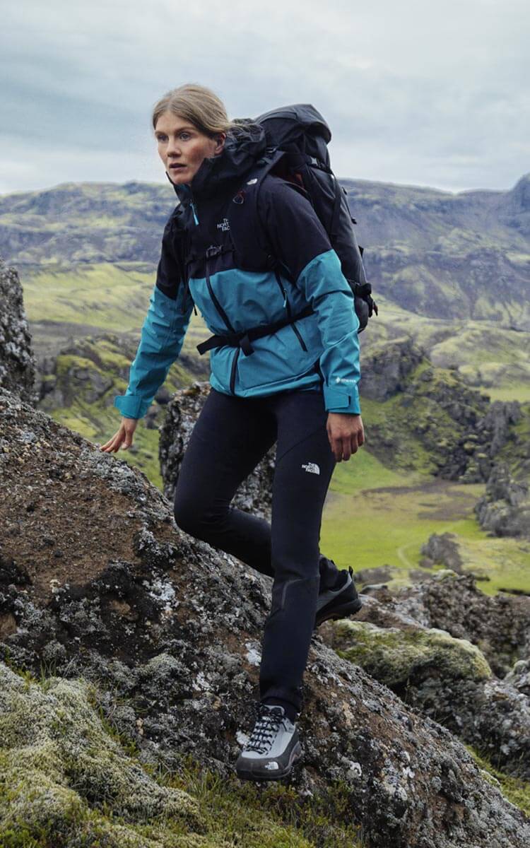 Ragazza che fa trekking in montagna con abbigliamento The North Face