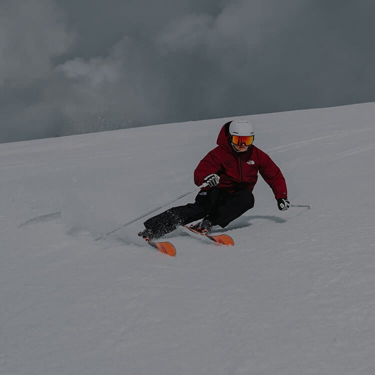 Ragazzo che fa slalom mentre che sci in montagna