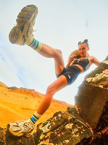 Ragazza in spiaggia che veste con sneakers New Balance 530