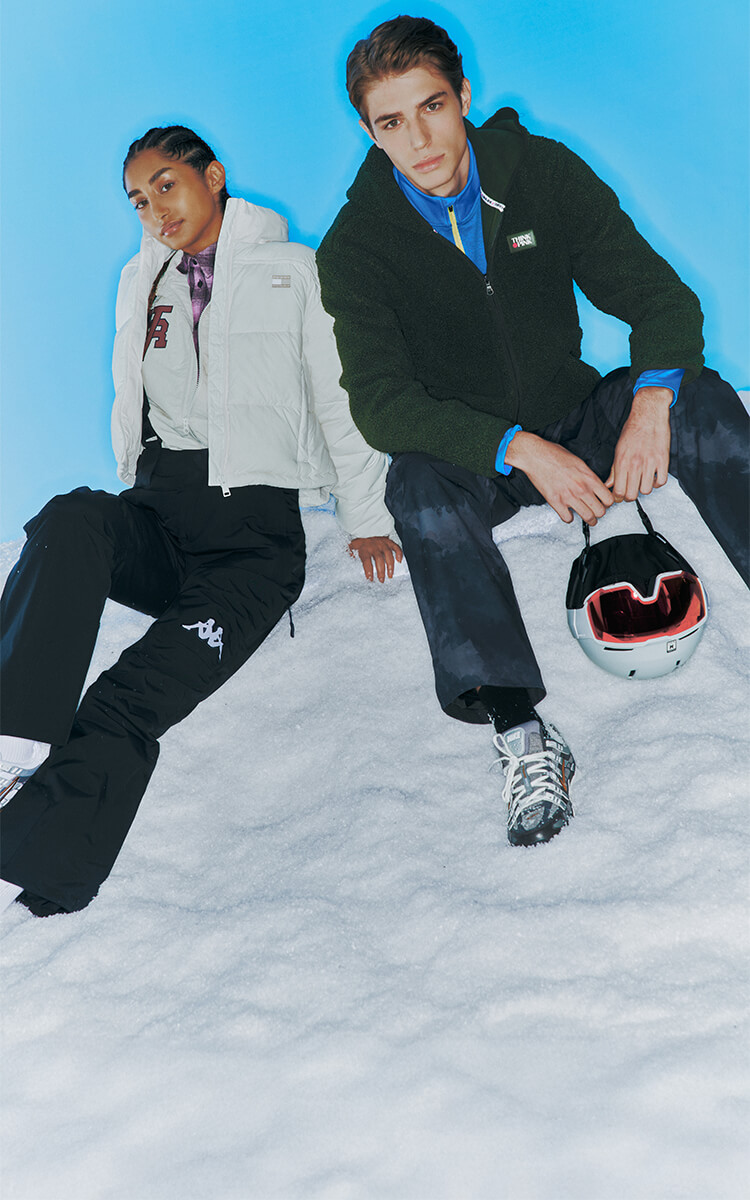 Ragazza con giacca bianca Tommy Jeans e pantaloni Kappa Sci e Ragazzo con pile Think Pink invernale