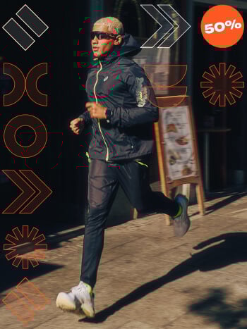 Ragazzo che corre su strada vestito con abbigliamento running Asics