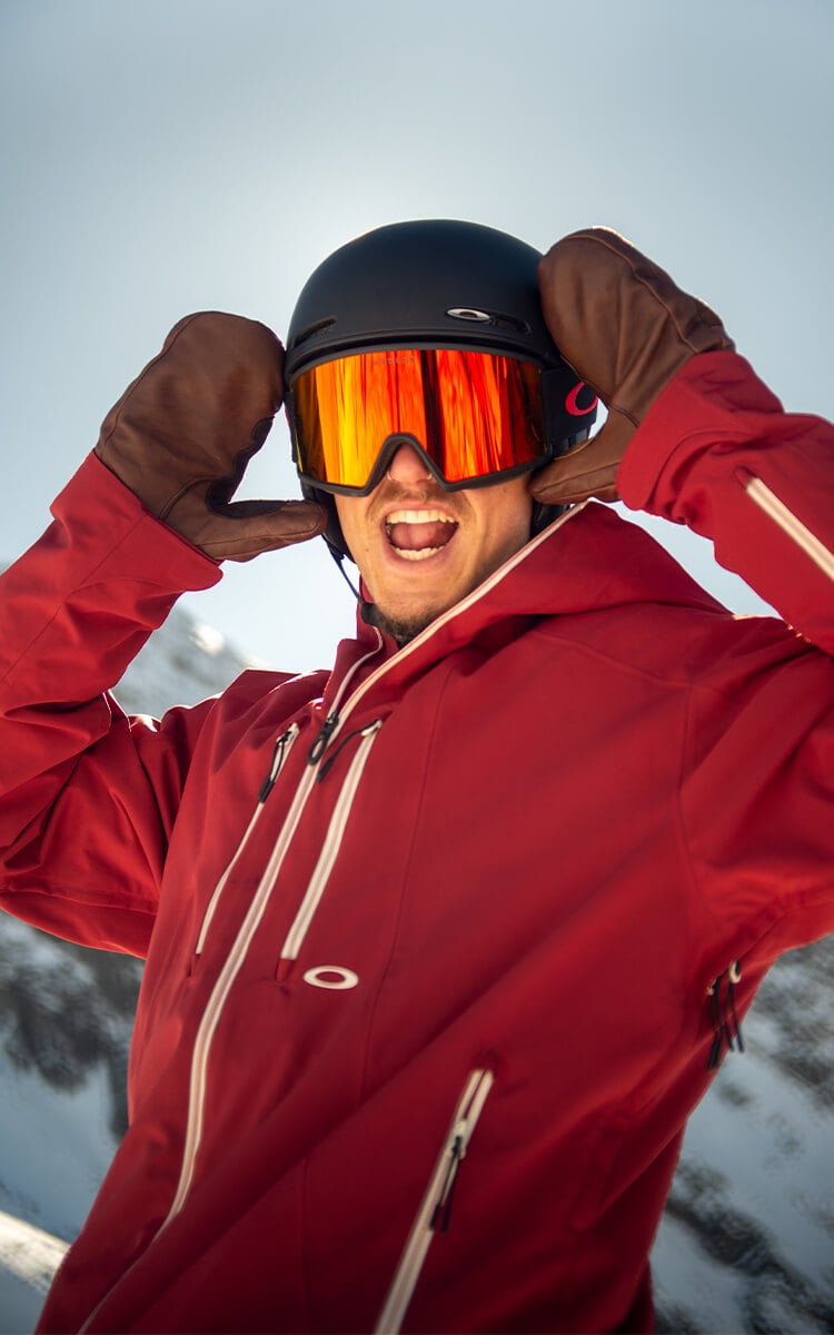 Ragazzo in pista da sci che indossa casco e maschera Oakley