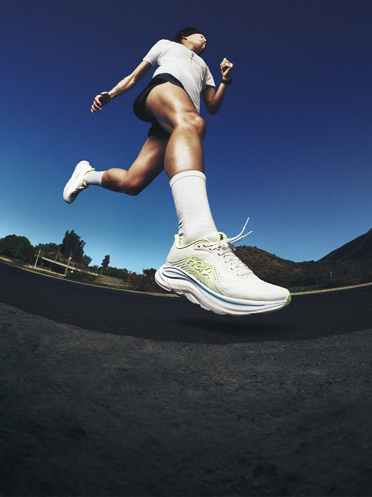 Donna che corre con scarpe da running Hoka Clifton 11