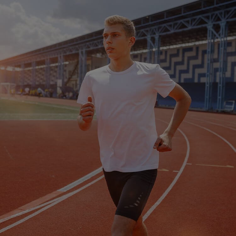 Ragazzo che si allena sulla pista di atletica