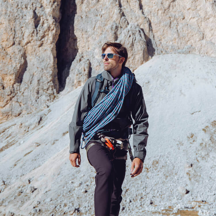 Ragazzo che cammina con attrezzatura di sicurezza in montagna