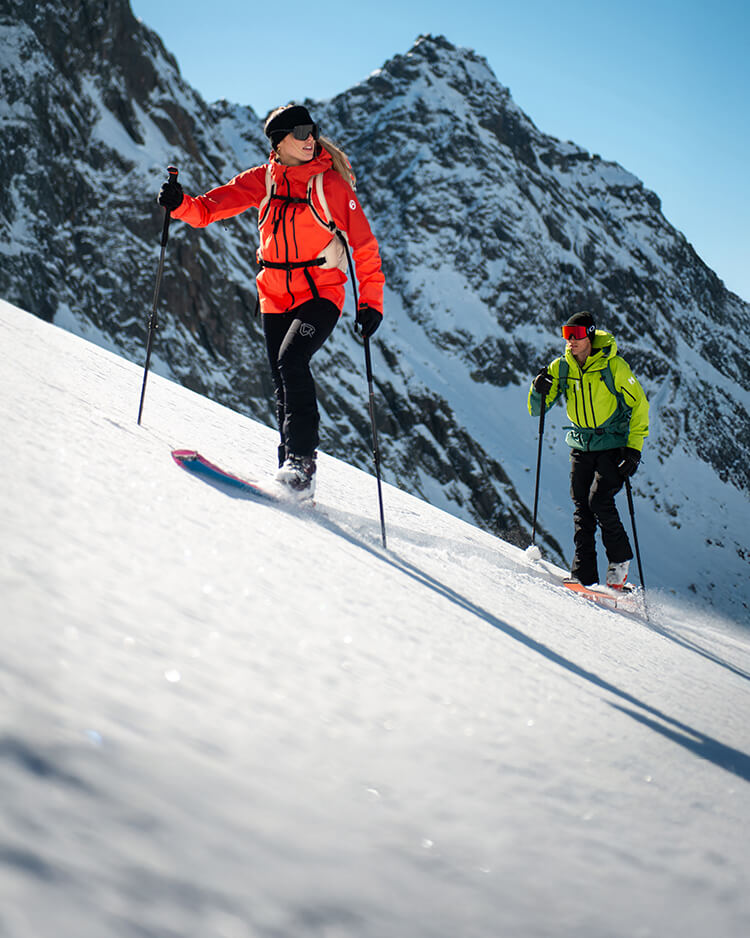 Ragazza e ragazzo che fanno sci alpinismo ad alta quota