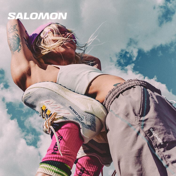 Ragazza che fa stretching con scarpe da trail running Salomon Gravel