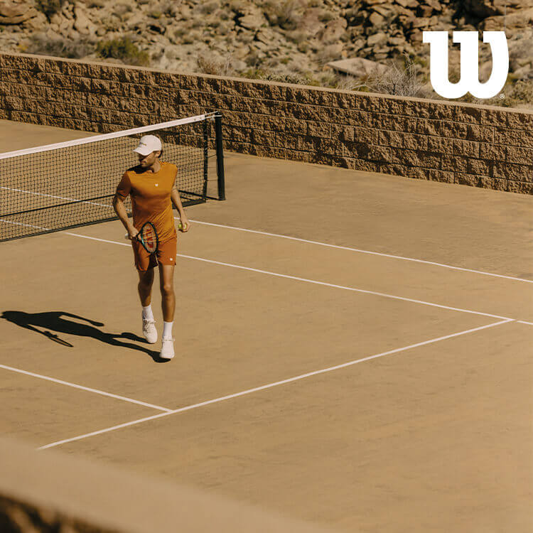 Ragazzo che gioca a tennis con abbigliamento Wilson