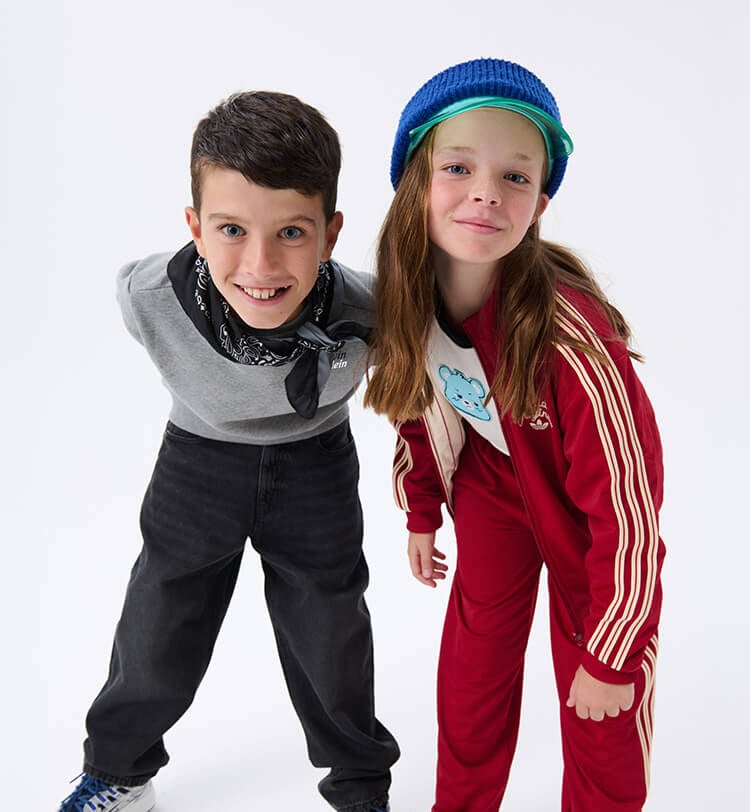 Bambina e bambino che indossano tuta adidas e abbigliamento streetwear