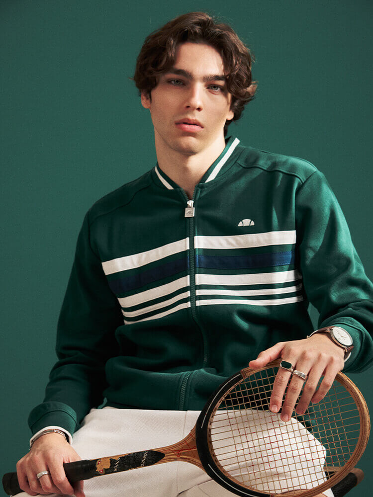 Ragazzo che indossa tuta tennis Ellesse verde e bianca