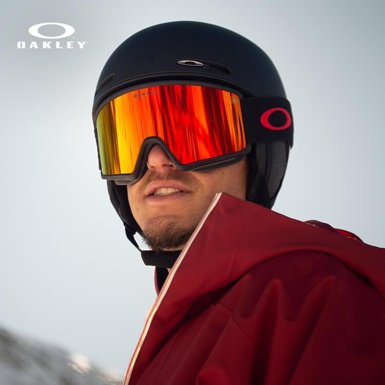 Ragazzo in pista da sci che indossa casco e maschera Oakley