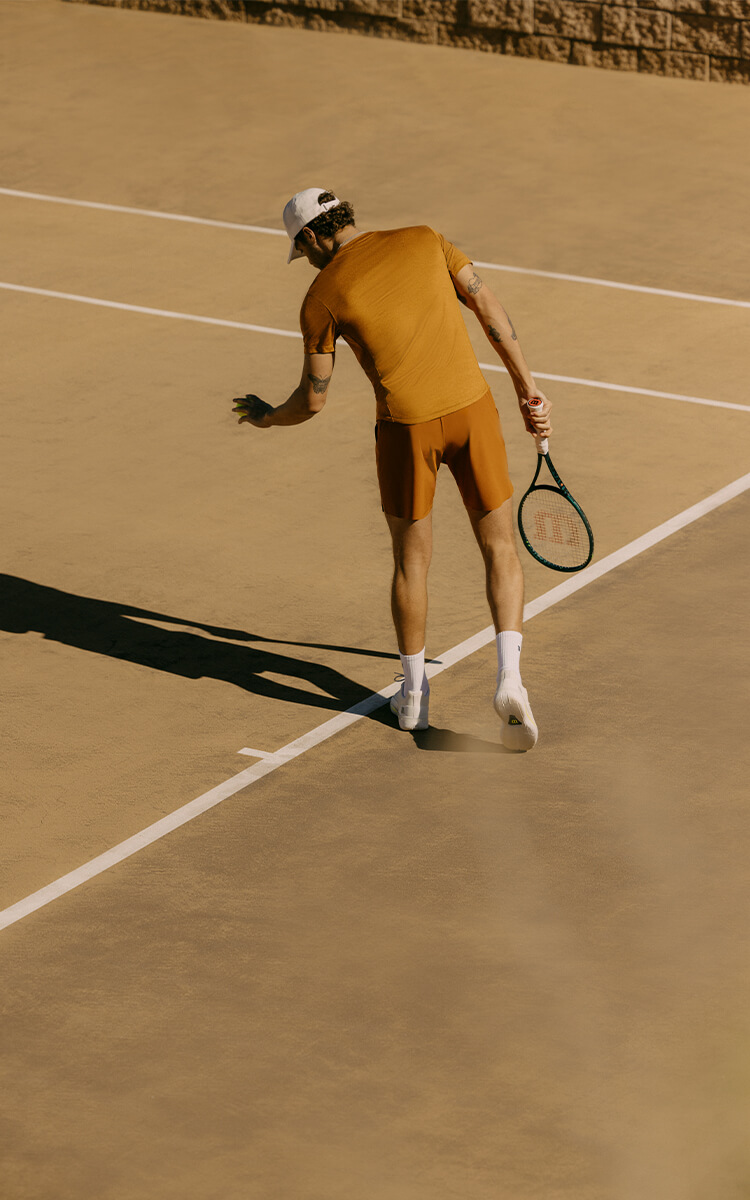 Ragazzo che gioca a tennis con abbigliamento Wilson