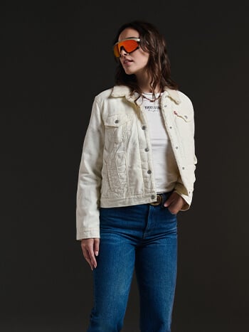 Ragazza che indossa abbigliamento autunnale giacca Levi's bianca e jeans