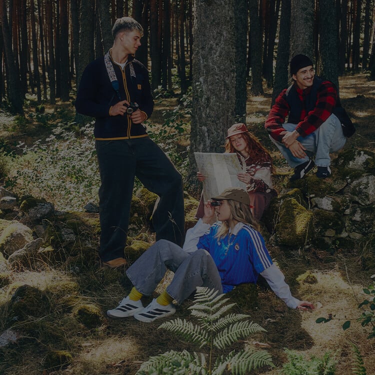 Gruppo di ragazzi nel chill in un bosco, vestiti con abbigliamento athleisure autunnale ed invernale.