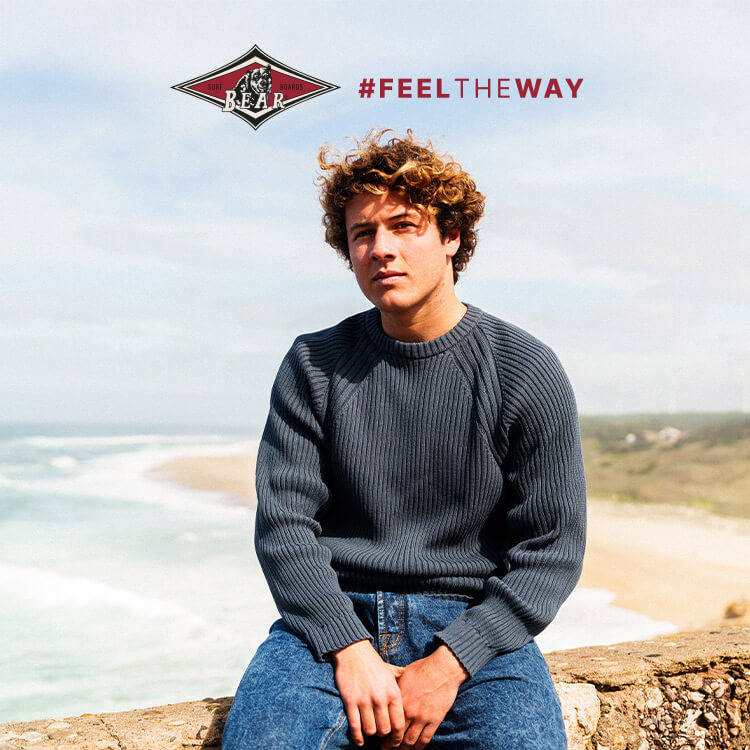 Ragazzo in spiaggia vestito in abbigliamento autunnale firmato Bear Surfboards