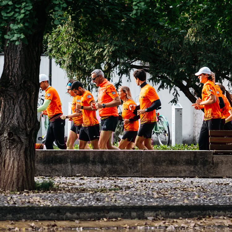 Gruppo di persone che corrono all'evento. Vestite con t-shirt running arancione di Cisalfa Sport