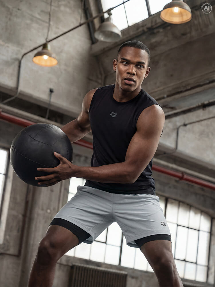 Ragazzo che si allena in palestra con palla medica vestito con Arena
