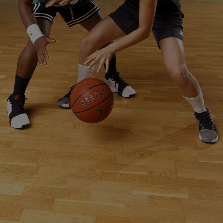 Due ragazzi che giocano a basket in palestra