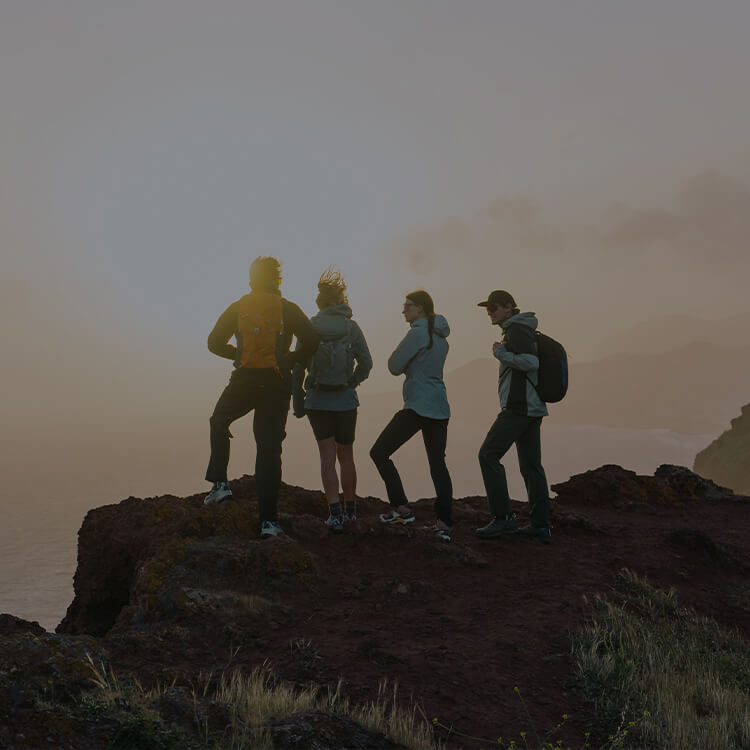 Gruppo di ragazzi che fa trekking in montagna al tramonto