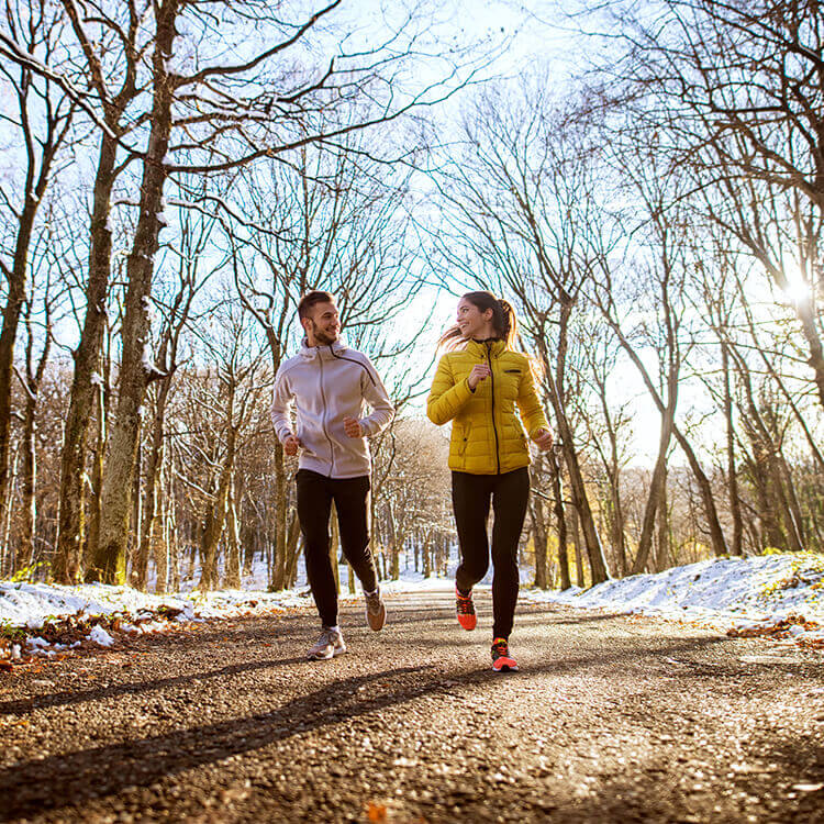 Ragazzi che corrono in inverno con giacche da running
