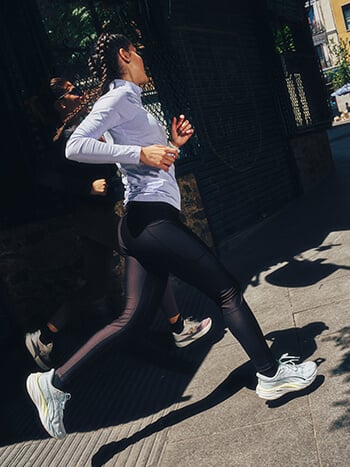 Ragazza che corre in città con abbigliamento autunnale