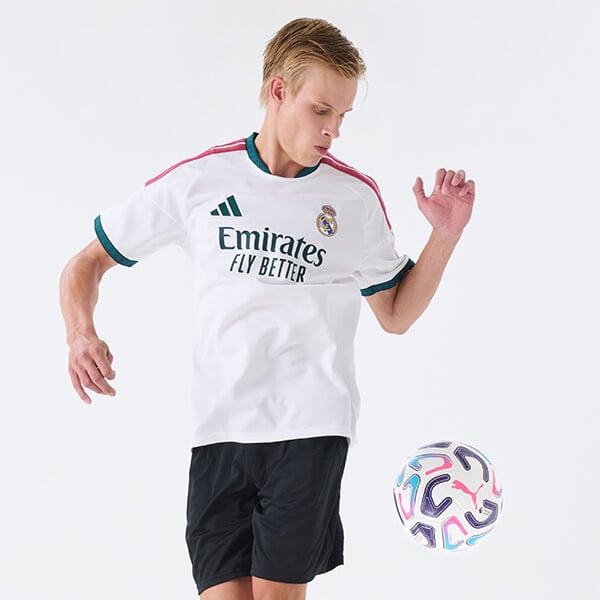 Ragazzo che indossa completo adidas calcio che gioca a football
