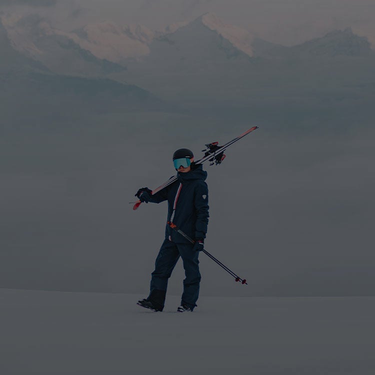 Ragazzo sulla neve con gli sci in mano 