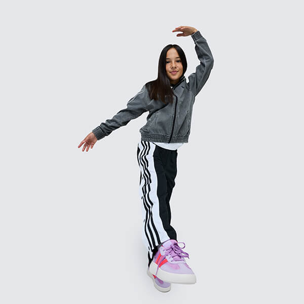 Bambina vestita con felpa, pantaloni tuta adidas e sneakers adidas rosa core