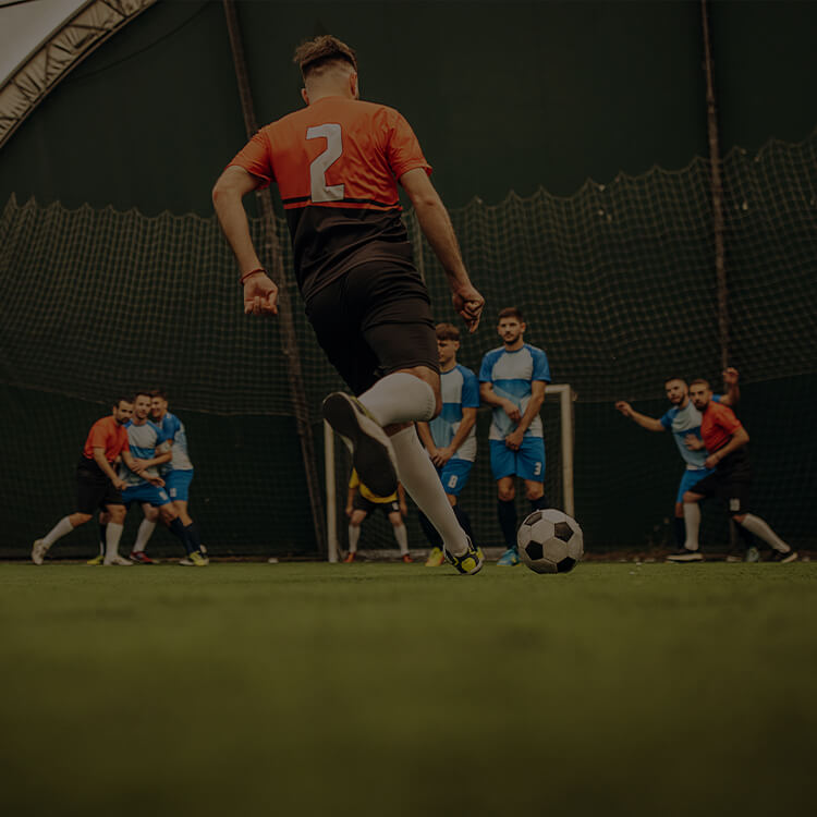 Ragazzi che giocano a calcio in campo indoor