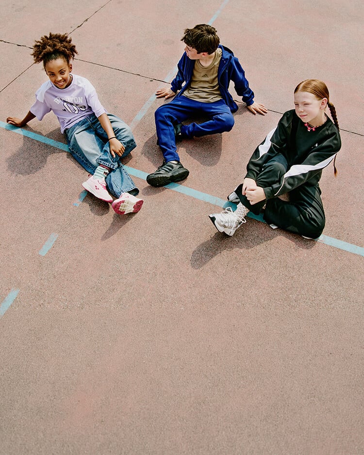 Gruppo di bambini seduti su campo da basket