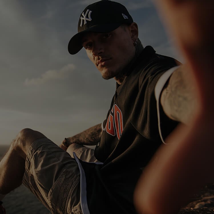 Ragazzo vestito con vestiti basket in riva al mare