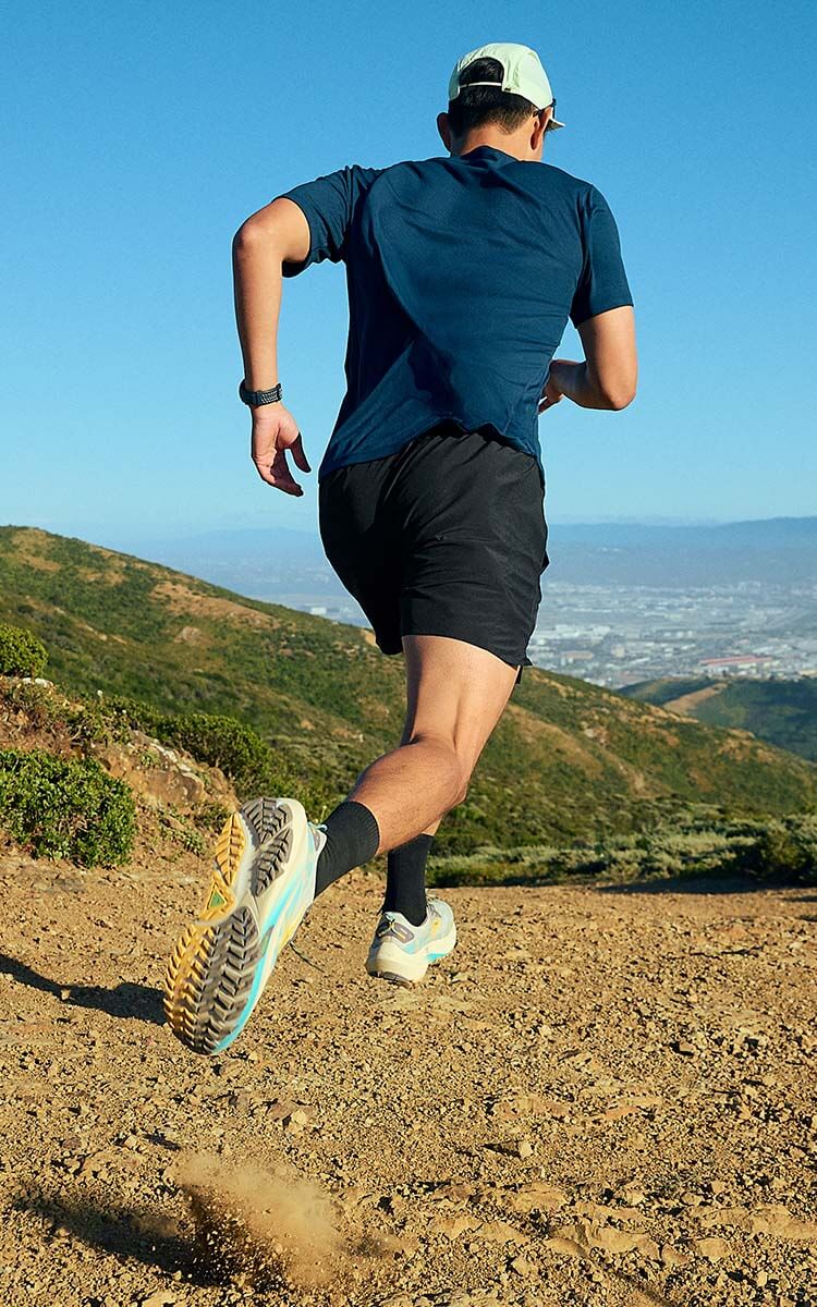 Ragazzo che corre in montagna con scarpe da trail Brooks Ghost Trail