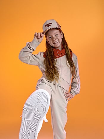 Bambina con cappellino e tuta rosa